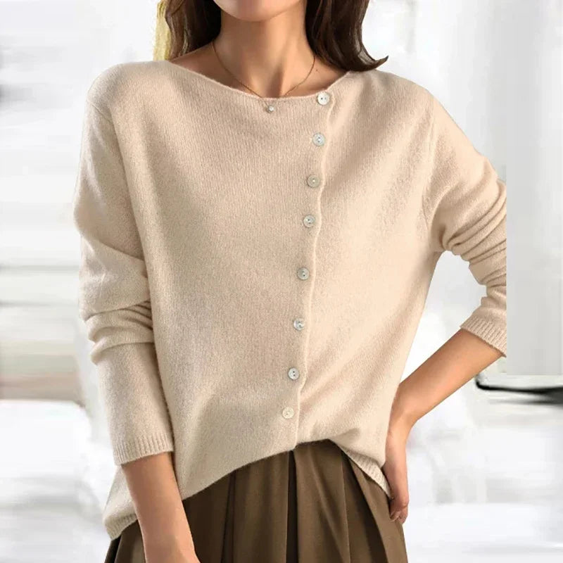 Femme portant un pull en laine bleu marine avec boutons, col en V, manches longues, style élégant et décontracté, mode automne-hiver tendance.